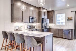 a kitchen with wooden cabinets and a counter with bar stools at Poolside Retreat - King Beds - Dog Friendly in St. George