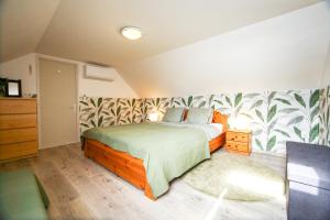 a bedroom with a bed with a green and white wallpaper at Bambuszkert in Kisoroszi