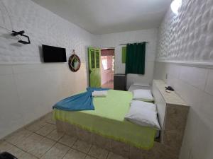 a bedroom with a bed and a green door at Pousada Golfinho in Galinhos
