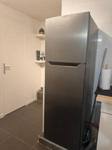 a stainless steel refrigerator in a kitchen at Rose CosyHome Paris Champs in Champs-sur-Marne +15 photos