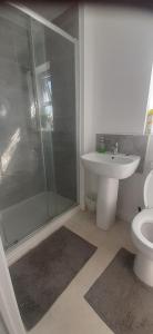 a bathroom with a shower and a toilet and a sink at Our Guests Are Royal (KE) in Higham Ferrers