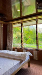a bedroom with a bed and a large window at Bagh Rustum Guest House in Holshāl