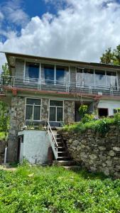a stone house with a stone wall and stairs at Bagh Rustum Guest House in Holshāl