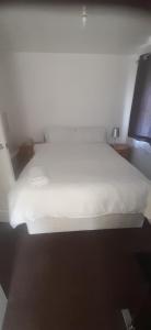 a bedroom with a white bed in a room at Our Guests Are Royal (KE) in Higham Ferrers