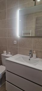a bathroom with a sink and a toilet and a mirror at L'ecrin de Provence in Beaumes-de-Venise +13 photos