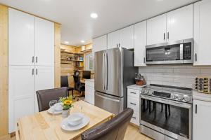 a kitchen with white cabinets and a wooden table with a dining room at Custer Love Shack in Custer