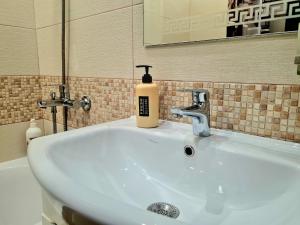 a bathroom sink with a bottle of soap on it at 43 Квартира in Bila Tserkva