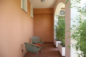 a corridor with two chairs and plants at Lumiére Marine in Roseto degli Abruzzi +14 photos