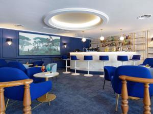 a restaurant with blue chairs and a bar at Mercure Marseille Centre Bompard La Corniche in Marseille