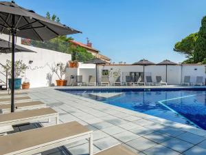 a swimming pool with chairs and an umbrella at Mercure Marseille Centre Bompard La Corniche in Marseille
