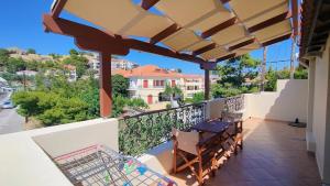 a patio with a table and chairs on a balcony at Afrodite Hotel Apartments in Myrina