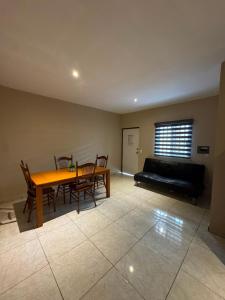 a living room with a table and chairs and a couch at Departamento #3 in San Carlos