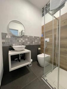 ein Badezimmer mit Waschbecken, Toilette und Spiegel in der Unterkunft Tra te e il Mare in Porto Torres
