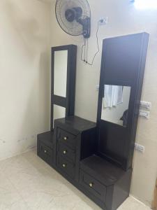 a black dresser with a mirror and a fan at مطل محنا الجبلي in Ajloun