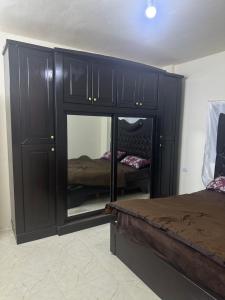 a black cabinet with a mirror in a bedroom at مطل محنا الجبلي in Ajloun