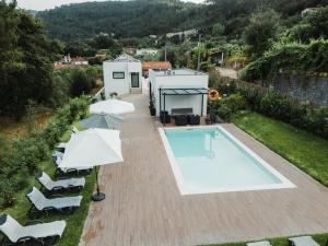 an overhead view of a swimming pool with umbrellas at Casas Peralta - Outeiro in Arouca