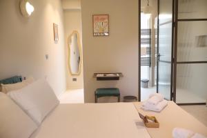 a bedroom with a large white bed and a chair at Lumiére Marine in Roseto degli Abruzzi