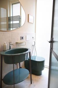 a bathroom with a green sink and a mirror at Lumiére Marine in Roseto degli Abruzzi