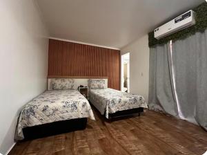 a bedroom with two beds and a window at Flat no centro de Curitiba in Curitiba +19 photos