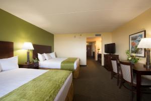 a hotel room with two beds and a desk at Edgewater Hotel and Waterpark in Duluth