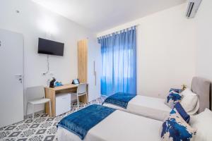 a hotel room with two beds and a desk at Casa iSuLa in Iglesias