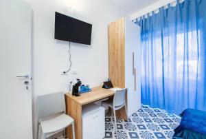 a room with a desk with a television and a bed at Casa iSuLa in Iglesias
