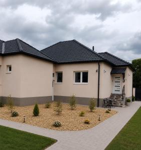 a white house with a black roof at Golden Home Törökbálint in Törökbálint