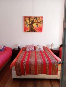 a bedroom with a bed and a painting on the wall at Hostal Casona del Canto in Los Andes