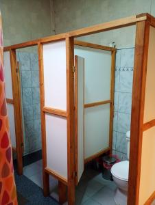 a bathroom with two glass doors and a toilet at Hostal Casona del Canto in Los Andes