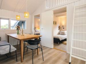 a dining room with a table and chairs and a bedroom at 5 star holiday home in Bindslev in Bindslev