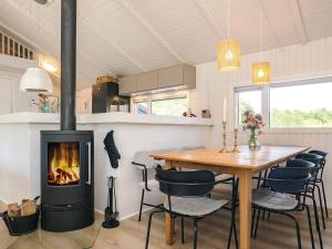 a dining room with a fireplace and a table and chairs at 5 star holiday home in Bindslev in Bindslev