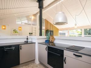 a kitchen with black and white counters and a sink at 5 star holiday home in Bindslev in Bindslev +30 photos