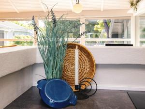a candle and a basket with a plant on a table at 5 star holiday home in Bindslev in Bindslev