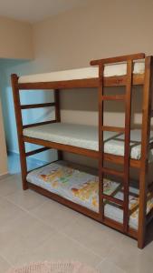 a wooden bunk bed with a mattress on the bottom shelf at Linda casa Edícula "fundos do terreno" com piscina in Itanhaém +67 photos