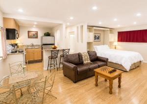a living room with a couch and a bed and a kitchen at King Frederik Inn in Solvang