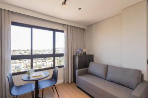 a living room with a couch and a table at Sky Design Residence in Barueri