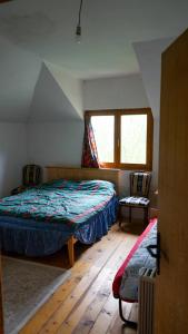 a bedroom with a bed and two chairs in it at Sopotnica - Apartman na vodopadima in Prijepolje