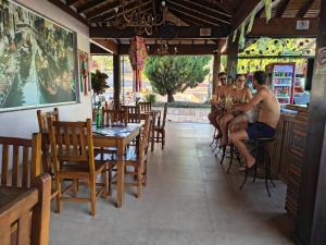 a group of people sitting at a bar in a restaurant at Hotel Pousada Villa Itália Olímpia in Olímpia