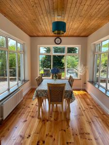 a dining room with a table and chairs and windows at Griggins House in Cur