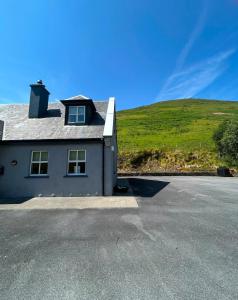 a house with a green hill in the background at Griggins House in Cur