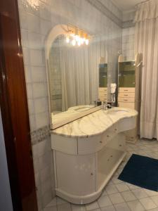 a bathroom with a sink and a large mirror at Abir's Apartments 2 in Marghera