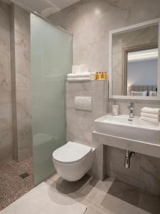 a bathroom with a toilet and a sink and a mirror at Studio Beleri in Himare +34 photos