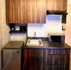 a small kitchen with a sink and a microwave at depa en el centro con estacionamiento in Monterrey