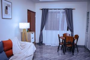 a living room with a table and chairs and a window at La Cas'a Yehud in Aoudja