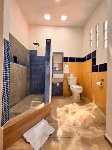 a bathroom with a tub and a toilet and a sink at Adarax Playa Hermosa in Cancún