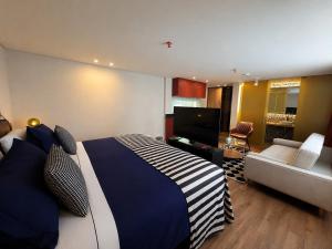 a bedroom with a bed and a living room at Hotel Oliver in Bogotá