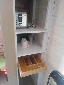 a kitchen cabinet with a coffee maker and a toaster at Connies Retreat in Gold Coast +4 photos