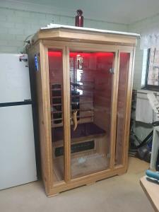 a wooden cabinet with a glass door in a room at Connies Retreat in Gold Coast