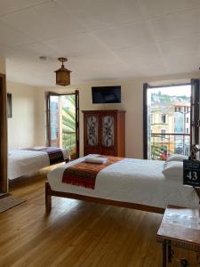a bedroom with two beds and a large window at Mía Leticia B&B in Quito