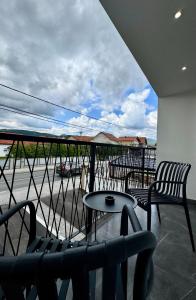 a balcony with chairs and a table and a view of a street at Apartmani SARA Bugojno in Bugojno